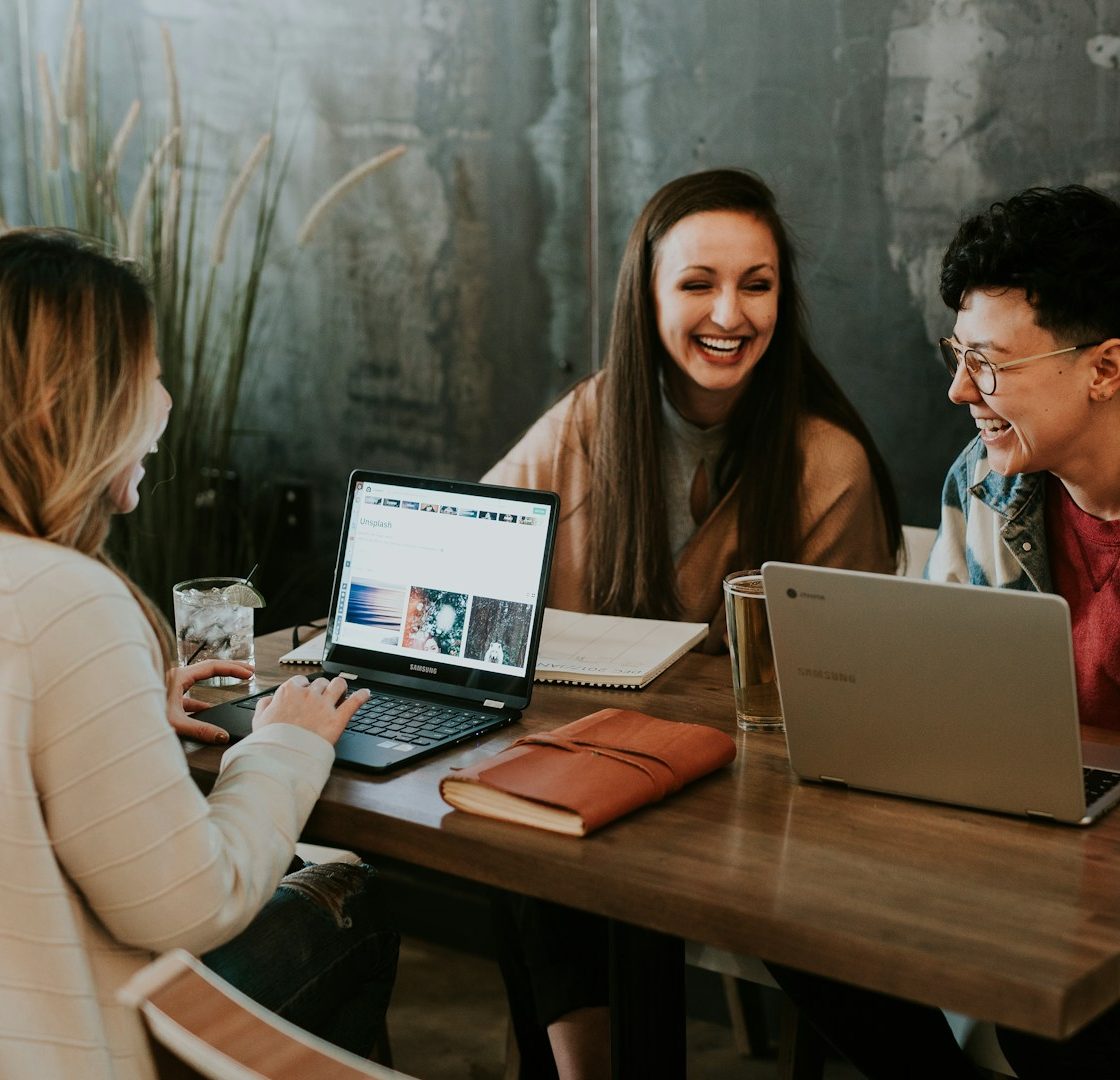 Drei Personen arbeiten kooperativ zusammen an Laptops. Community-Learning